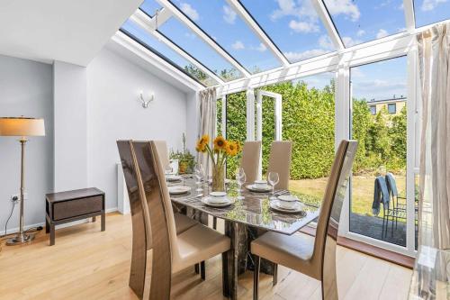 StonewoodにあるSpacious 3-Bedroom Retreat with Garden Near Bluewaterのダイニングルーム(ガラスのテーブル、椅子付)
