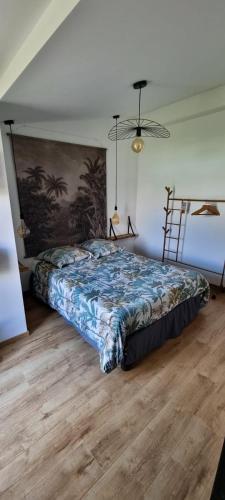 une chambre avec un lit avec un tableau sur le mur dans l'établissement Ty Grain de Sel : logement privatif avec piscine, jardin et patio, à Chauvé