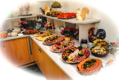 a kitchen with many plates of food on a counter at Hotel Garni Sonne in Ahlbeck