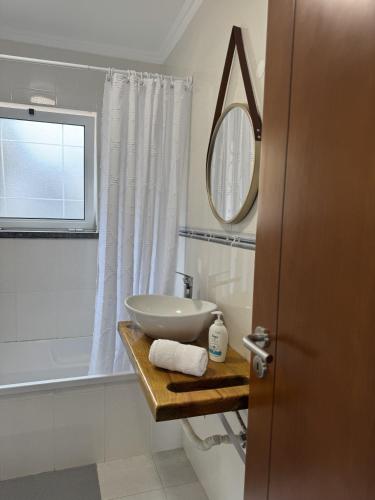 a white bathroom with a sink and a mirror at Apartamentos do Triângulo in Velas