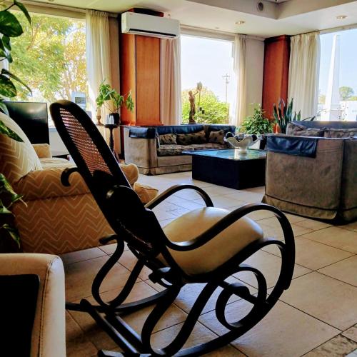a chair in a living room with a couch at Hotel Aguaý in Gualeguaychú