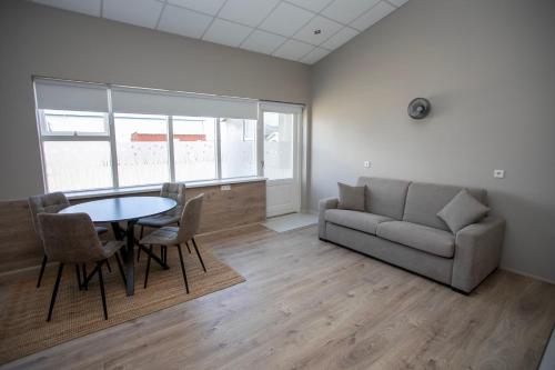a living room with a couch and a table and chairs at Skýjaborg Apartments in Höfn