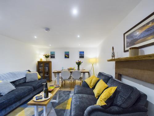 a living room with a blue couch and a table at Joiners cottage in Penrith