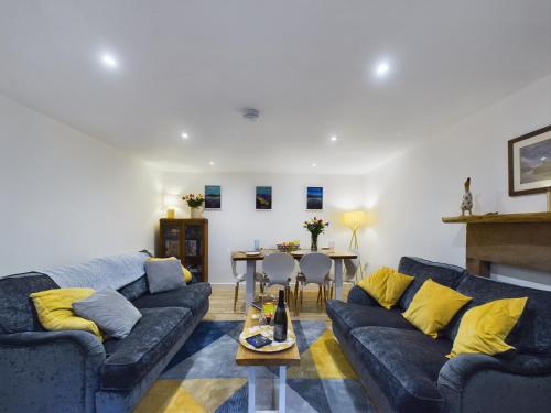 a living room with two couches and a table at Joiners cottage in Penrith
