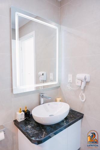 a bathroom with a sink and a mirror at Latritcia Boutique Hotel in Cat Ba
