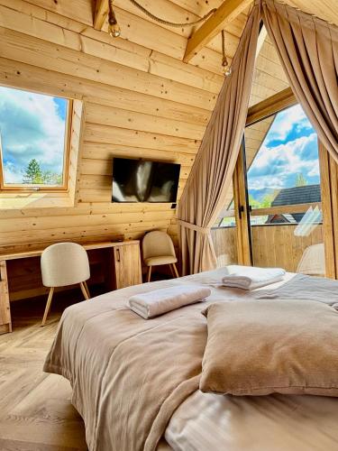a bedroom with a bed in a wooden cabin at Zakątek Zakopane in Zakopane