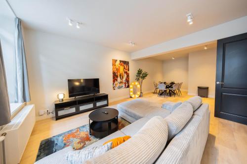 a living room with a white couch and a tv at Alphabet Apartments - Jufferstraat 10 in Rotterdam