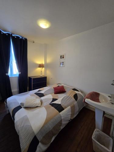une chambre avec un lit et un lavabo dans l'établissement le meublé d 'Alex, à Étretat