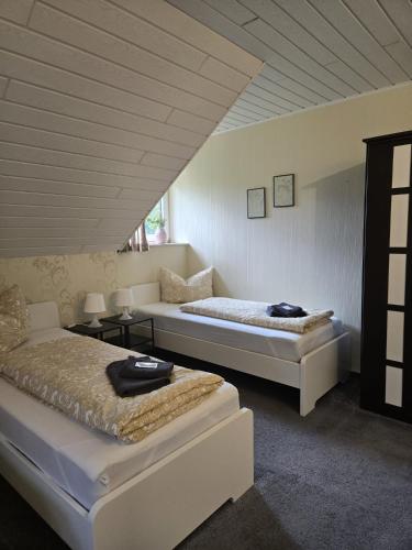 a bedroom with two beds in a room at Pension Platzhirsch Eichsfeld in Geisleden