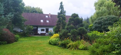 a house in a garden with flowers and trees at Chalupa na Hutích in Příbraz