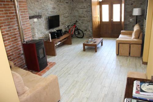 a living room with a couch and a tv at Casa do Ferrador in Mirandela
