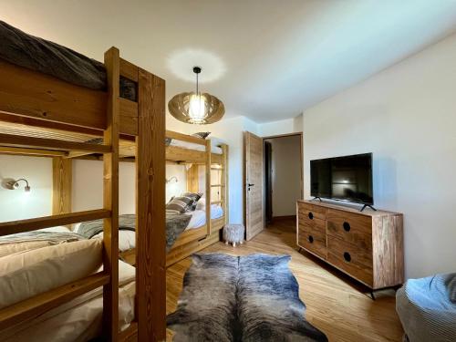 - une chambre avec 2 lits superposés et une télévision à écran plat dans l'établissement Homency - Résidence Cachemire A304, à L'Alpe-d'Huez