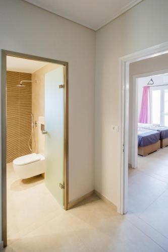 a bathroom with a door leading to a bedroom at Villa Kotetsi in Laganas