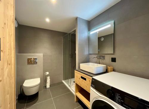une salle de bain avec toilettes et lavabo et une machine à laver dans l'établissement Homency - Résidence Cachemire A304, à L'Alpe-d'Huez