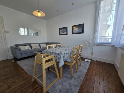 un salon avec une table, des chaises et un canapé dans l'établissement le meublé d 'Alex, à Étretat