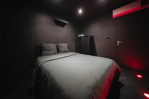 - une chambre avec un lit dans une pièce éclairée dans l'établissement Cinéma & Expérience 4K - Popcorn OFFERT, à Saint-Étienne