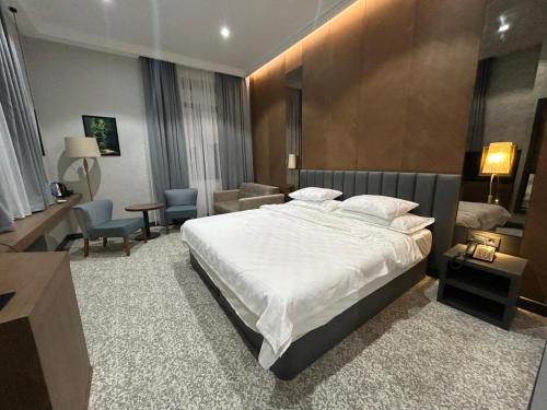 a bedroom with a large bed and a living room at Green Village HOTEL & SPA in Sis