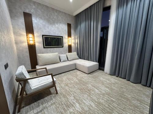 a living room with a white couch and a chair at Green Village HOTEL & SPA in Sis