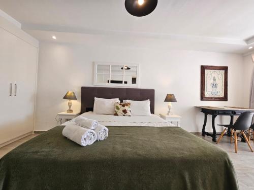 a bedroom with a large bed and a desk at Kilandu Village in Búzios