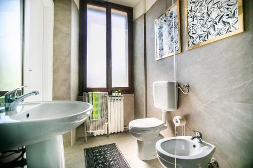 Un baño con un lavabo blanco y un inodoro. en Dimora Vico, en Como