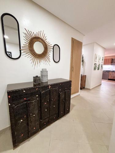 a room with a dresser and a mirror on the wall at Escapade Tropicale at Jardins Cherrat in Bouznika Bay in Bouznika
