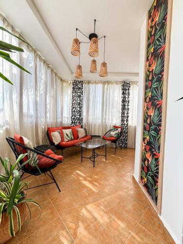 a living room with a couch and chairs and a table at Escapade Tropicale at Jardins Cherrat in Bouznika Bay in Bouznika