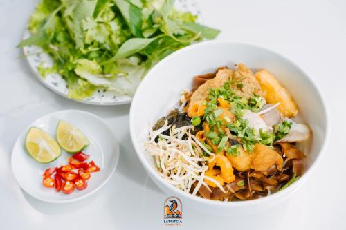 drie kommen met eten op tafel, inclusief salade bij Latritcia Boutique Hotel in Cat Ba