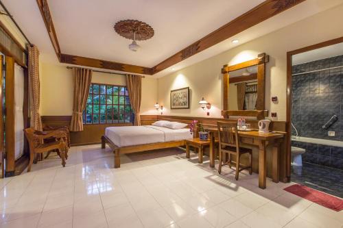 een slaapkamer met een bed, een bureau en een wastafel bij Duta Garden Hotel in Yogyakarta