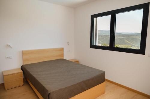 a bedroom with a bed and a window at Casa do Tojo (Camélias de Basto - Turismo Rural) in Pedras Alvas