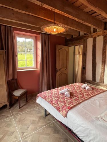 une chambre avec un lit et une fenêtre dans l'établissement La Charretrie, à Pierrefitte-en-Auge