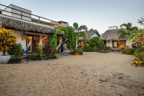 a group of houses with thatched roofs and a courtyard at Nordisch- Chalés in Prea