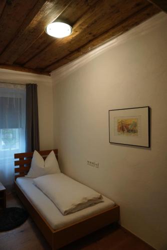 a small bed in a room with a ceiling at Apartment Enzinger in Bruck an der Mur