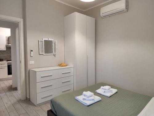 une chambre avec un lit et une commode avec des serviettes dans l'établissement Maison Blanche, à Varazze