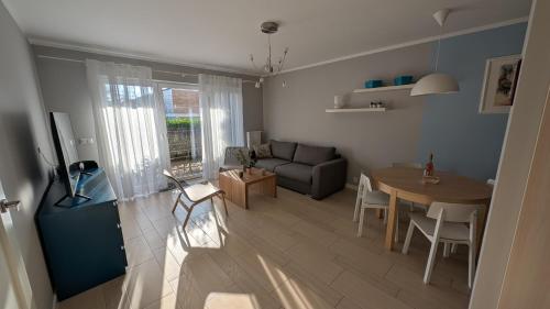 una sala de estar con una mesa y un sofá en Apartamenty Morze Wygody, en Międzywodzie