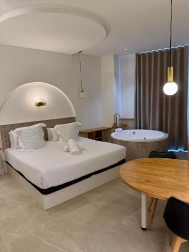 a bedroom with a bed and a tub and a table at Reina Victoria El Mercado in Alicante