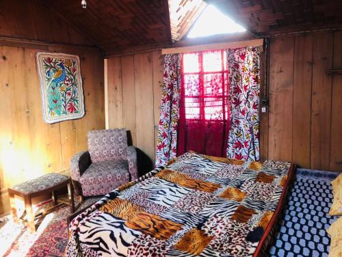 una camera da letto con un letto, una sedia e una finestra di Budshah Palace House Boat a Srinagar