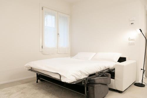 a white bed in a room with a window at Ca Borsa III - Suite nel cuore di Treviso in Treviso