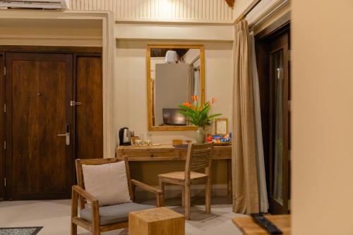 a room with a desk and chairs and a mirror at Crown Retreat Quy Nhon Resort in Quy Nhon