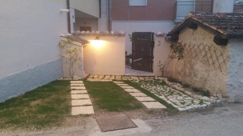 a small backyard with a door and a grass yard at Lu Passittu in Norcia