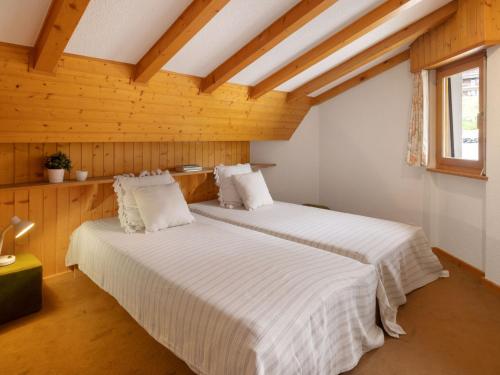 two beds in a room with wooden walls at Apartment Eldorado 321 by Interhome in Verbier