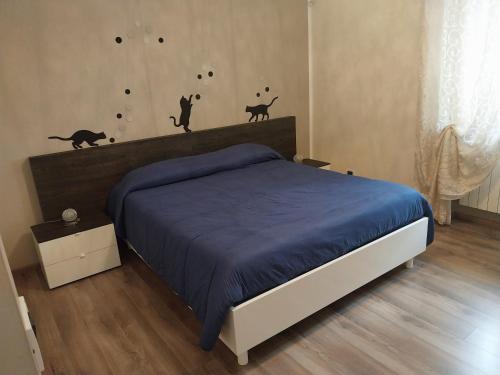 a bedroom with a bed with two cats on the wall at Ľ angolo della quaquara in Genola