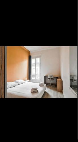 une chambre avec un grand lit blanc et une fenêtre dans l'établissement Appartement 3 pièces, à Nice