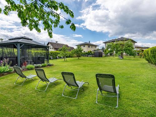 three chairs sitting in the grass in a yard at Apartment Ogris-2 by Interhome in Selpritsch