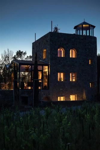 a large stone building with its lights on at Castello Di Vicarello in Sasso dʼOmbrone