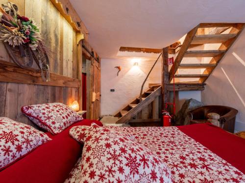 a bedroom with a red bed with a red comforter at Apartment Baita Baulin-1 by Interhome in Baulen