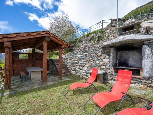 two chairs and a table in front of a stone building at Apartment Baita Baulin-1 by Interhome in Baulen