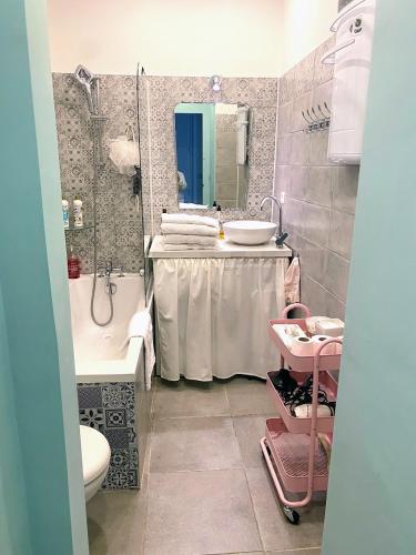 La salle de bains est pourvue d'un lavabo, d'une baignoire et d'un porte-parole. dans l'établissement Au coeur de Marseille, à Marseille