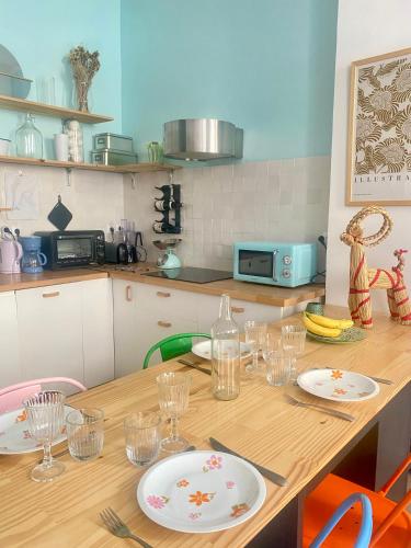 une cuisine avec une table en bois, des assiettes et des verres dans l'établissement Au coeur de Marseille, à Marseille