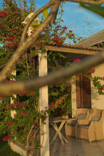 a patio with two chairs and red flowers at Crown Retreat Quy Nhon Resort in Quy Nhon