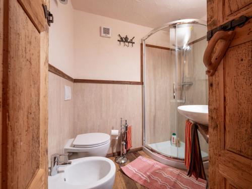 a bathroom with a toilet and a sink and a shower at Apartment Baita Baulin-2 by Interhome in Baulen